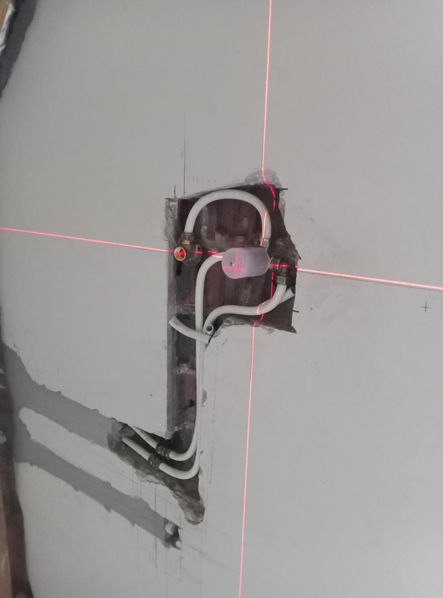 Concealed plumbing pipework aligned with a laser level